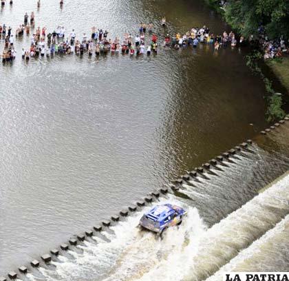El público del Rally Dakar presencia cómo el piloto español Carlos Sainz cruza el río Santa Rosa al volante de su coche Volkswagen