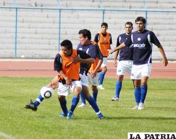 Isaías Dury disputa el balón con Marcos Paz; observan  Vieira y Juárez