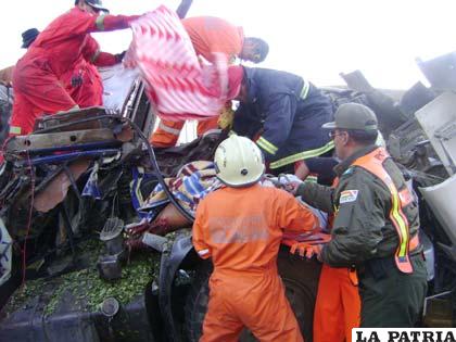 Bomberos y miembros del Grupo SAR, tratando de rescatar el cuerpo del conductor que transportaba coca