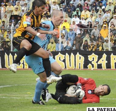 El golero de Bolívar, Marcos Arguello se esfuerza para controlar el balón, ante la arremetida de los atacantes del Tigre.