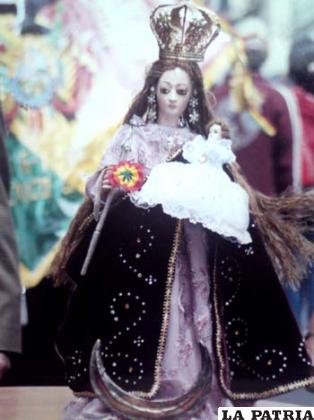 La sagrada imagen de la Virgen del Socavón en México, al fondo la Tricolor boliviana