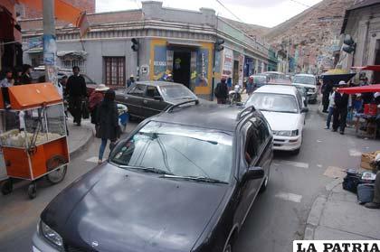 Vehículos, comerciantes y peatones disputándose un espacio en las calles