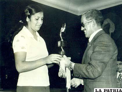 El Gral. Gastón Gambule Dulón, ex prefecto de Oruro, entrega un trofeo a Elena García, considerada la mejor voleibolista del año 1976 por el Círculo de Periodistas Deportivos de Oruro