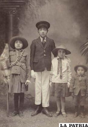 Los cuatro hijos vestidos con uniformes de Boys Scouts de la época