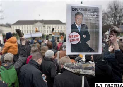 Fotografía de las cientos de personas que se han manifestado ante el palacio del presidente de Alemania, Christian Wulff, con sus zapatos en alto