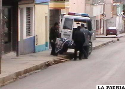 Efectivos policiales trasladan el cuerpo sin vida, a la morgue de un centro médico de Oruro
