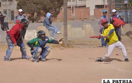 El ampáyer, el catchers y el bateador, en una acción de juego del béisbol