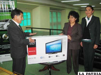 Funcionarios del Banco Mercantil Santa Cruz, entregan el premio a la feliz ganadora