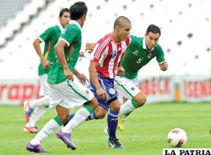 El centrocampista de Paraguay Jorge Rojas compite por el balón con el defensa Carlos Añez Bolivia (I.) y el alero Carlos Paniagua durante el Sudamericano Sub-20 Grupo A