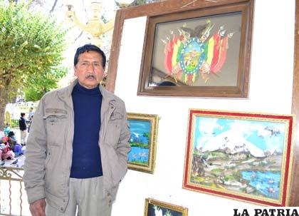 El artista Eddy Pinto junto al Escudo de Bolivia hecho con plumas
