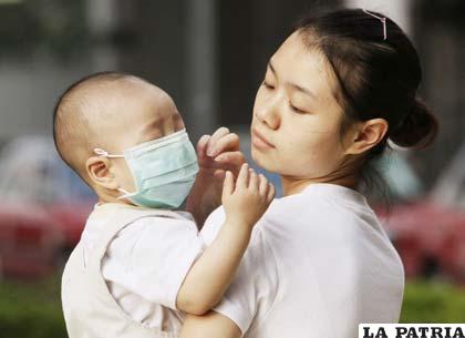 Una mujer china cuida la salud de su hijo
