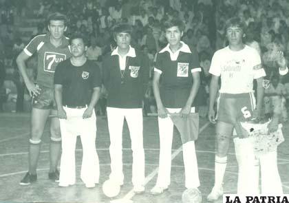 Los capitanes Enrique Aguirre de Metalúrgica Andina de Cochabamba y Rubén Veizaga de Huracán de Oruro, junto a los árbitros en la final del nacional de fútbol de salón realizado en Sucre el año 1979