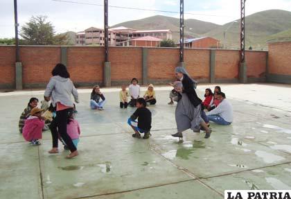 Niños juegan con la religiosa Catalina Kaminska