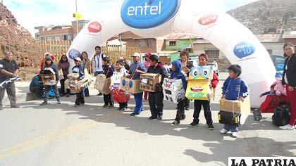 Niños con sus vehículos fabricados por ellos mismos reciclando objetos