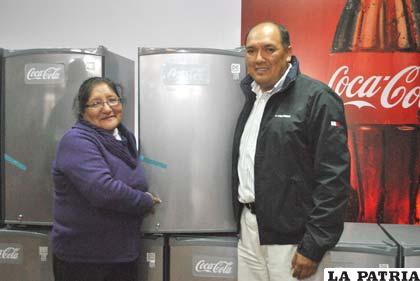 El gerente regional de Embol, Fernando Gómez, entregando el refrigerador a una de las ganadoras