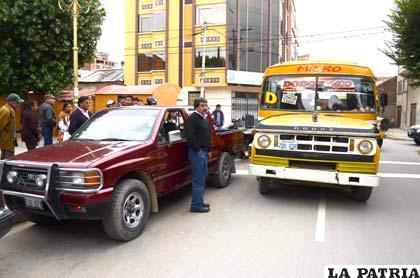 Ambos coches protagonistas y de fondo las comerciantes