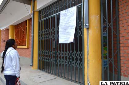 Una madre de familia lee el instructivo colocado en uno de los establecimientos educativos de la ciudad