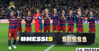 Lionel Messi enseña a su público el quinto Balón de Oro, ante la mirada de sus compañeros de equipo