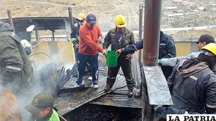 Trabajadores con balde en mano ayudaron a apagar el incendio