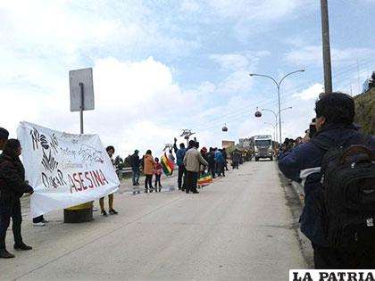 Activistas apostados en la autopista con un gran cartel en rechazo del Dakar /ANF