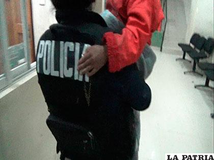 La menor es llevada en brazos por una policía