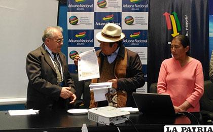 El gerente de la Aduana, Oscar Arancibia recibe la Ley de manos del alcalde Contreras