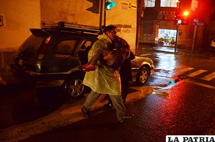 El funcionario policial en brazos lleva a la niña a la Asistencia Pública