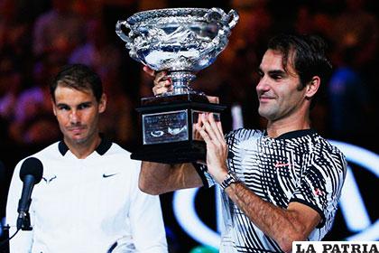 Federer levanta el trofeo de campeón, ante la mirada de Nadal