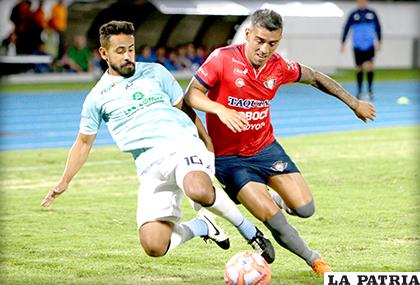 Charles Da Silva intenta dominar el balón ante la marca de su adversario/ APG
