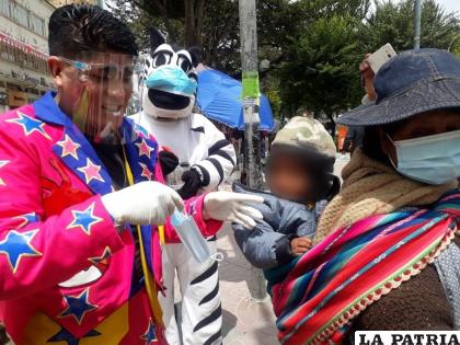 Momento en el que un integrante del elenco, entrega barbijos a la madre y su niño  /LA PATRIA