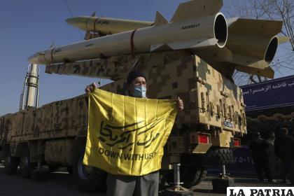 Un hombre muestra una pancarta con lemas contra Estados Unidos frente a los misiles Zolfaghar (arriba), Dezful (abajo) y Qiam (al fondo a la izquierda) 
/aP Foto/Vahid Salemi