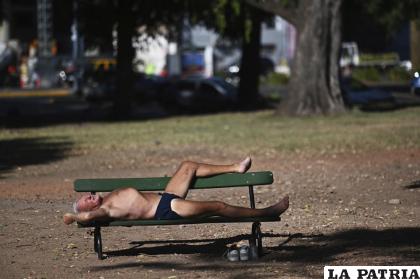 Un hombre toma el sol en un banco de un parque en los Bosques de Palermo en Buenos Aires /Foto AP/Mario De Fina
