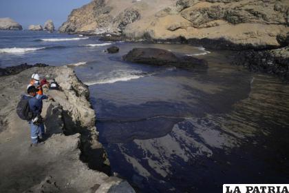 Los trabajadores observaron el petróleo en las aguas de la playa Cavero en Perú /Foto AP/MartÍn Mejía