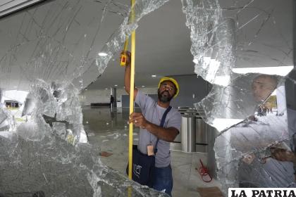 Trabajadores reemplazan ventanas quebradas del Palacio Planalto /AP Foto/Eraldo Peres