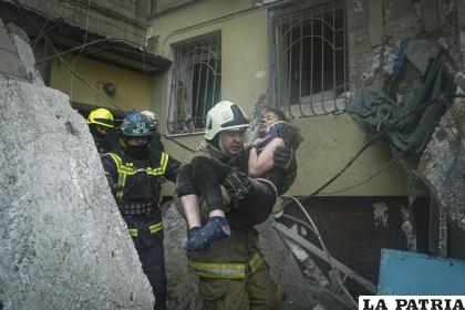 Un bombero lleva a una mujer herida fuera de los escombros de un edificio tras un ataque ruso el sábado en Dnipro /Pavel Petrov, SESU via AP
