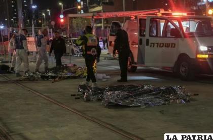 Personal médico cubre los cadáveres de víctimas de un ataque cerca de una sinagoga, en Jerusalén /AP