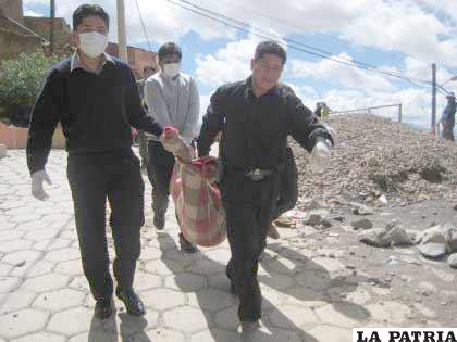 Efectivos policiales trasladan el cadáver