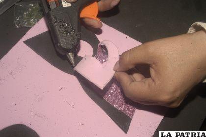 PASO 5
Pegar la goma EVA con brillantina rosada sobre la base del antifaz de goma EVA color negro.
