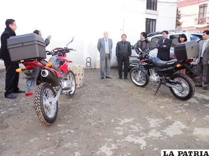 Autoridades judiciales junto a las motocicletas que se entregaron a los notificadores