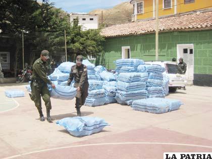 Efectivos policiales trasladan sacos de botas dotadas por el Gobierno