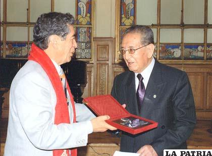 Augusto Dávila (derecha) recibe de Armando Peredo la plaqueta de distinción “Honor al Mérito” otorgada por la CAO