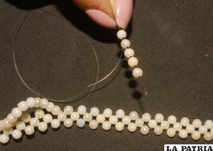 PASO 4
Luego insertar cinco perlas y cerrar ingresando por la cuarta perla contando de afuera, formando una especia de cruz y salir por la perla de la flor de 4.
