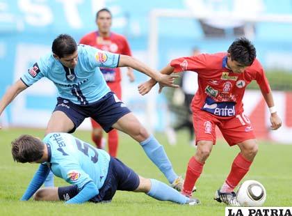 Rivero y Alvarez intentan arrebatarle el balón a Pachi