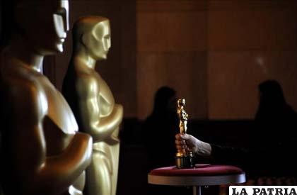Un operario coloca un premio Oscar durante la apertura de la exposición que mostrará algunas de las estatuillas de los premios Oscar de Hollywood que se entregarán en su 84 edición. 
