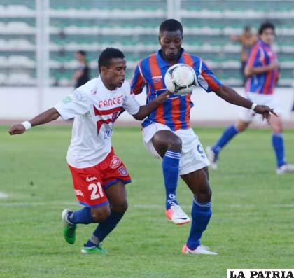 Ballivián, de Universitario, disputa el balón con Charrupi, de La Paz FC