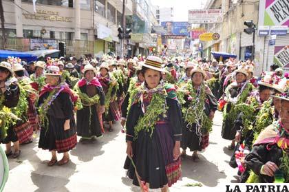 Mujeres cargadas de plantas como símbolo de la producción