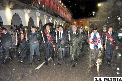 Las principales autoridades ingresan en plena lluvia durante el desfile de teas