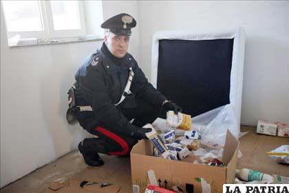 Un carabinero de la policía militar italiana, muestra objetos encontrados, pertenecientes a Cutrì