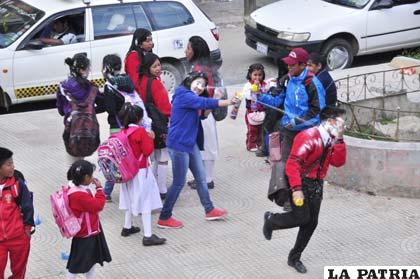 Estudiantes juegan en las calles con espuma y agua en bolsas