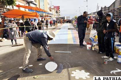 Artistas plásticos trabajando en medio de comerciantes 